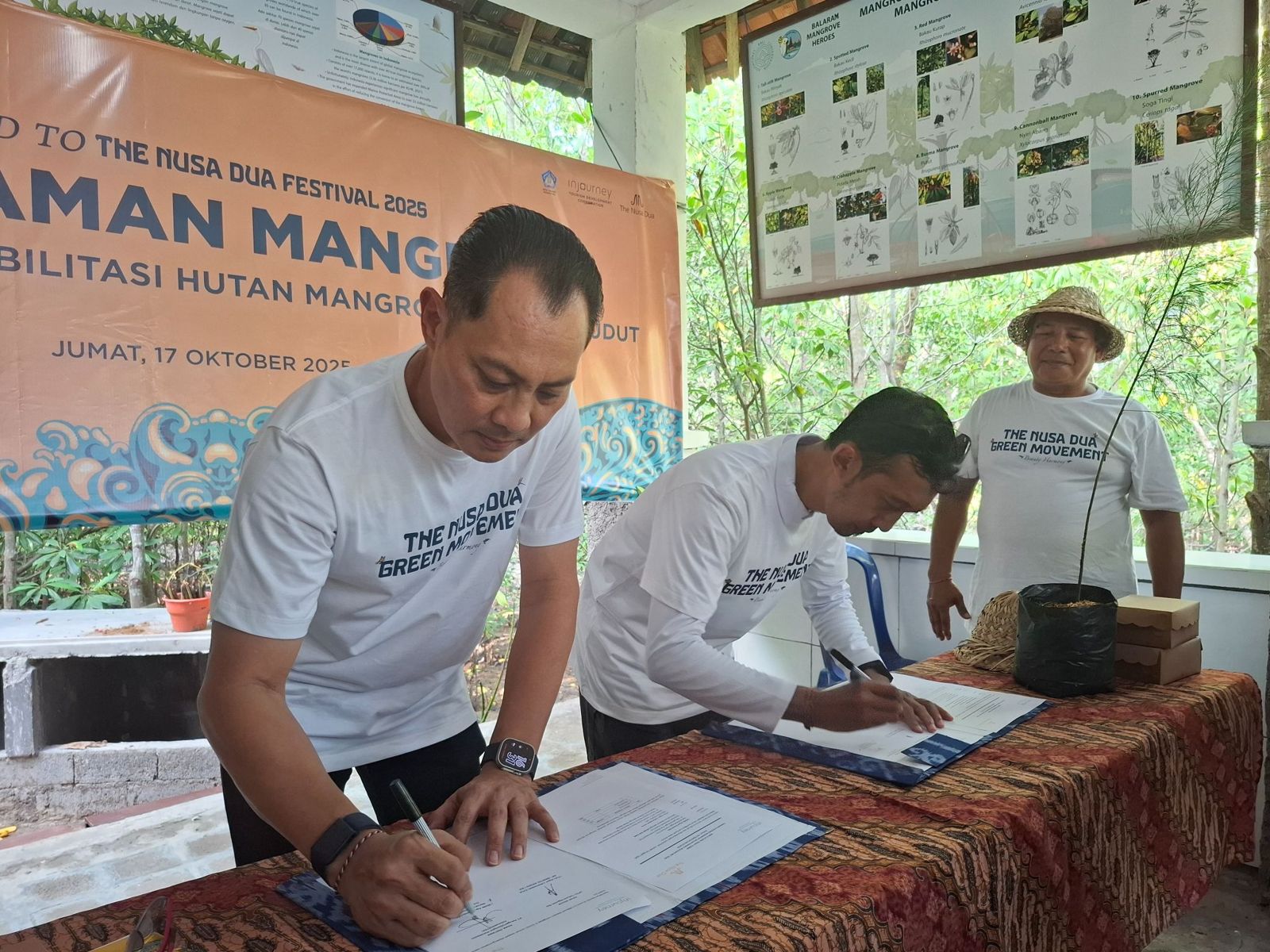 Partners signing an agreement at a mangrove event